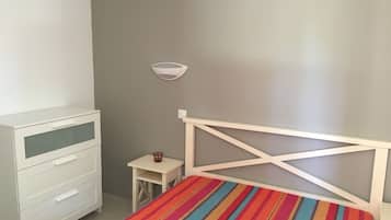 2 dormitorios y tabla de planchar con plancha