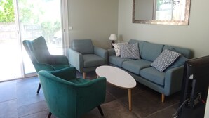 A living room with a teal armchair, a grey sofa, a small white table, and a television. - House / Villa - Lège-Cap-Ferret (Lège-Cap-Ferret)