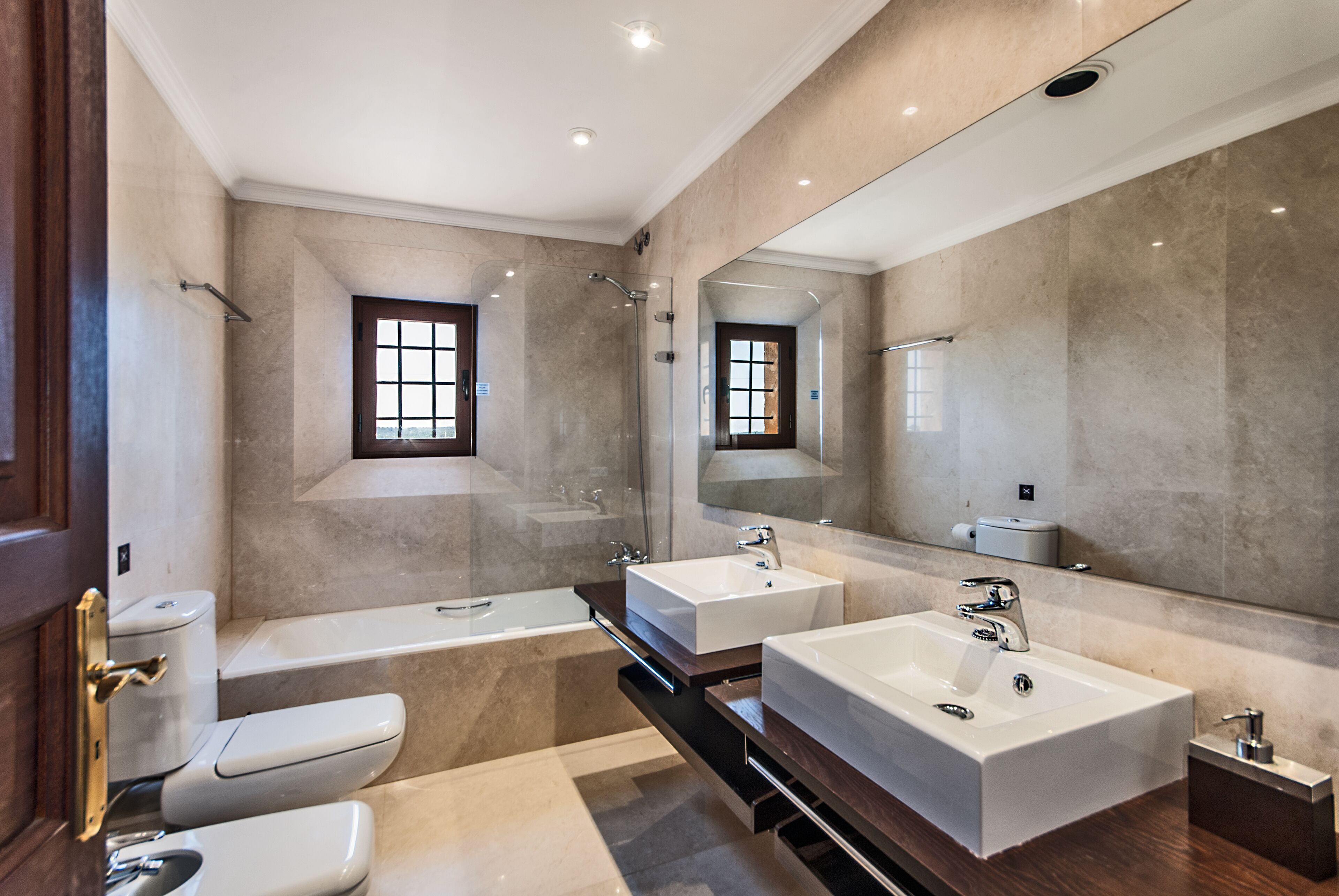 Een bad/douchecombinatie, een haardroger, een bidet, handdoeken