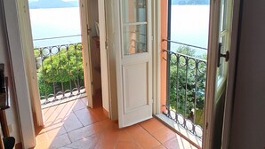 Un pasillo que da a un balcón con vistas a un lago y montañas.