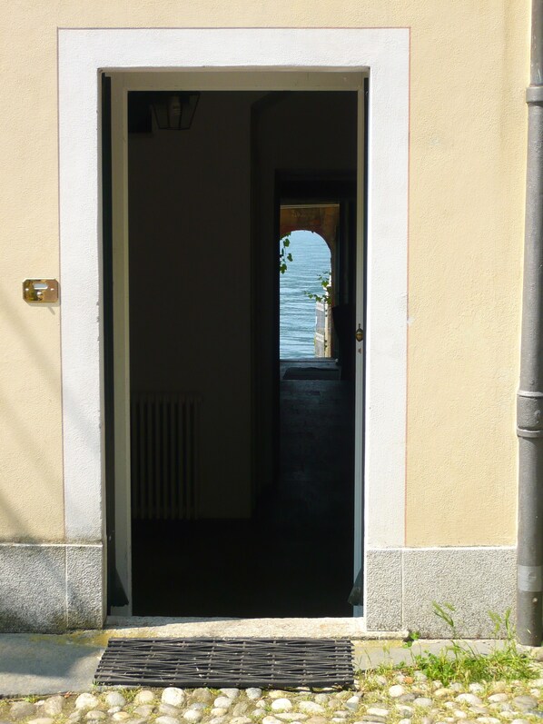 Una puerta que da a un espacio exterior cubierto con vista al mar.