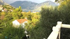 A residential area with houses, dense greenery, and mountains in the background. - Large Luxury Stone Villa With Private Infinity Pool And Sea Views (Southern Coastal)