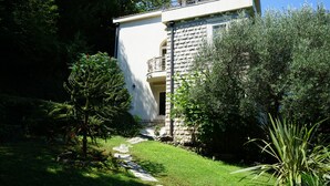 A two-story building with a stone facade, a balcony, and a stone pathway leading to the entrance. - Large Luxury Stone Villa With Private Infinity Pool And Sea Views (Southern Coastal)