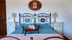 A neatly arranged bedroom with a bed, bedside tables, and a bedside lamp.