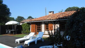 A house with a tiled roof, a swimming pool, and outdoor seating.