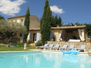 A pool area with lounge chairs and a shark float.
