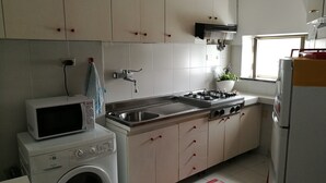A kitchen with a washing machine, microwave, sink, stove, and cabinets. - Seaside holiday home in Bonassola, Madonnina della Punta, near Cinque Terre (bonassola)