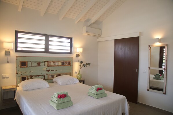 Habitación de hotel con cama, dos lámparas de noche, una ventana, un espejo y una puerta.