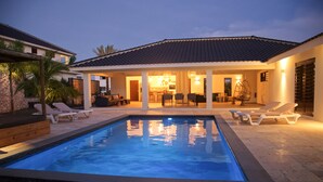 A swimming pool with lounge chairs, a covered patio area, and a stone exterior. - *UNIQUE*: Luxury, tropical villa within walking distance of Jan Thiel Beach (6p) (Jan Thiel)
