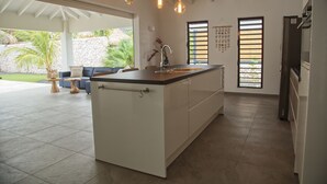 A modern kitchen with an island, pendant lighting, and a view of the outdoors. - *UNIQUE*: Luxury, tropical villa within walking distance of Jan Thiel Beach (6p) (Jan Thiel)