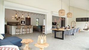 A spacious living area with a kitchen, dining table, and seating arrangements. - *UNIQUE*: Luxury, tropical villa within walking distance of Jan Thiel Beach (6p) (Jan Thiel)