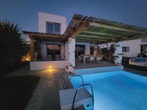 Une maison moderne dotée d’une piscine, de mobilier d’extérieur et d’un espace patio.