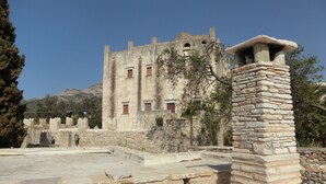 A historic stone building with multiple windows and a stone chimney.
