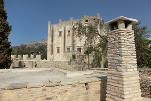 A historic stone building with multiple windows and a stone chimney.