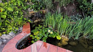 A garden with a pond, water lilies, and various plants. - 5-star villa. Air-conditioned. Secure. Exceptional sea view, Swimming pool (Saint-Raphaël)