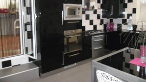 A modern kitchen with black cabinets, a microwave, an oven, and a sink.