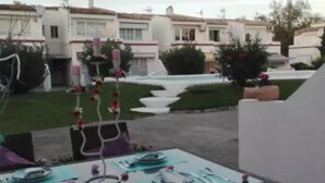An outdoor dining area with tables set for a meal, surrounded by a garden with flowers and a pool. - Ground floor with garden and barbecue, 5 minutes from the beach (Alcudia)