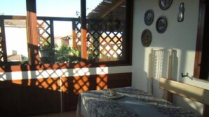 A room with a bed, a window with a view of the outside, and a wall with a few decorations. - Apartment/ flat - Budoni (Budoni)