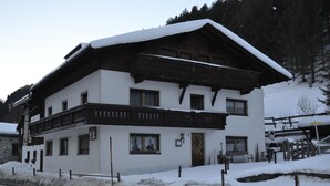 A two-story building with a snow-covered roof and wooden balconies.
