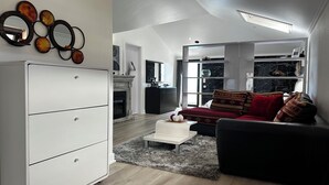 Ein modernes Wohnzimmer mit einem weißen Schrank, einem roten Sofa und einem Kamin.