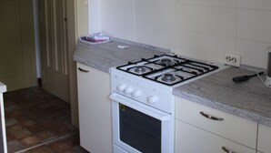 A kitchen with a gas stove, white cabinets, a white oven, and a light fixture. - Forest, water, stone, "small Canada" in the middle of Saxony. (Kirchberg)