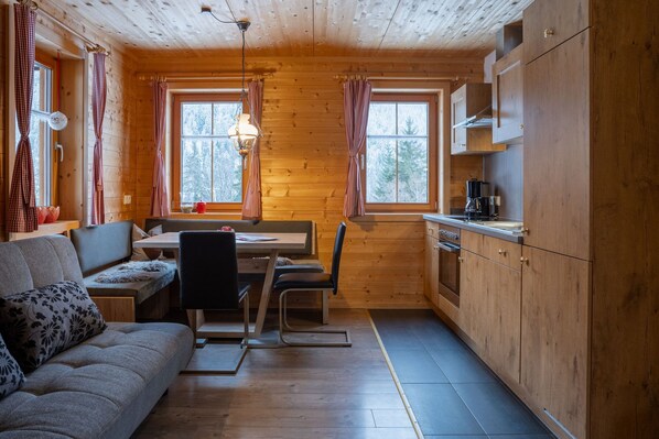 A cozy cabin with a dining area, a sofa, and a kitchen.