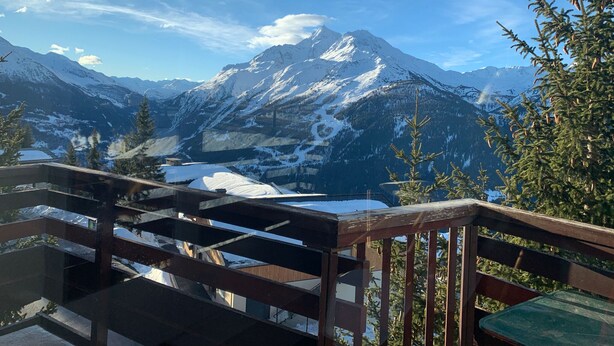A mountain view from a balcony with a wooden railing, overlooking snow-covered peaks and a clear sky. - Cosy refurbished 2 bedroom apartment, Sleeps 6. Close to slopes (Montvalezan)
