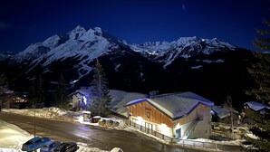 A snow-covered mountain at night with a lit building in the foreground. - Cosy refurbished 2 bedroom apartment, Sleeps 6. Close to slopes (Montvalezan)