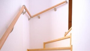 Una escalera de madera con barandilla, sin muebles ni adornos visibles.