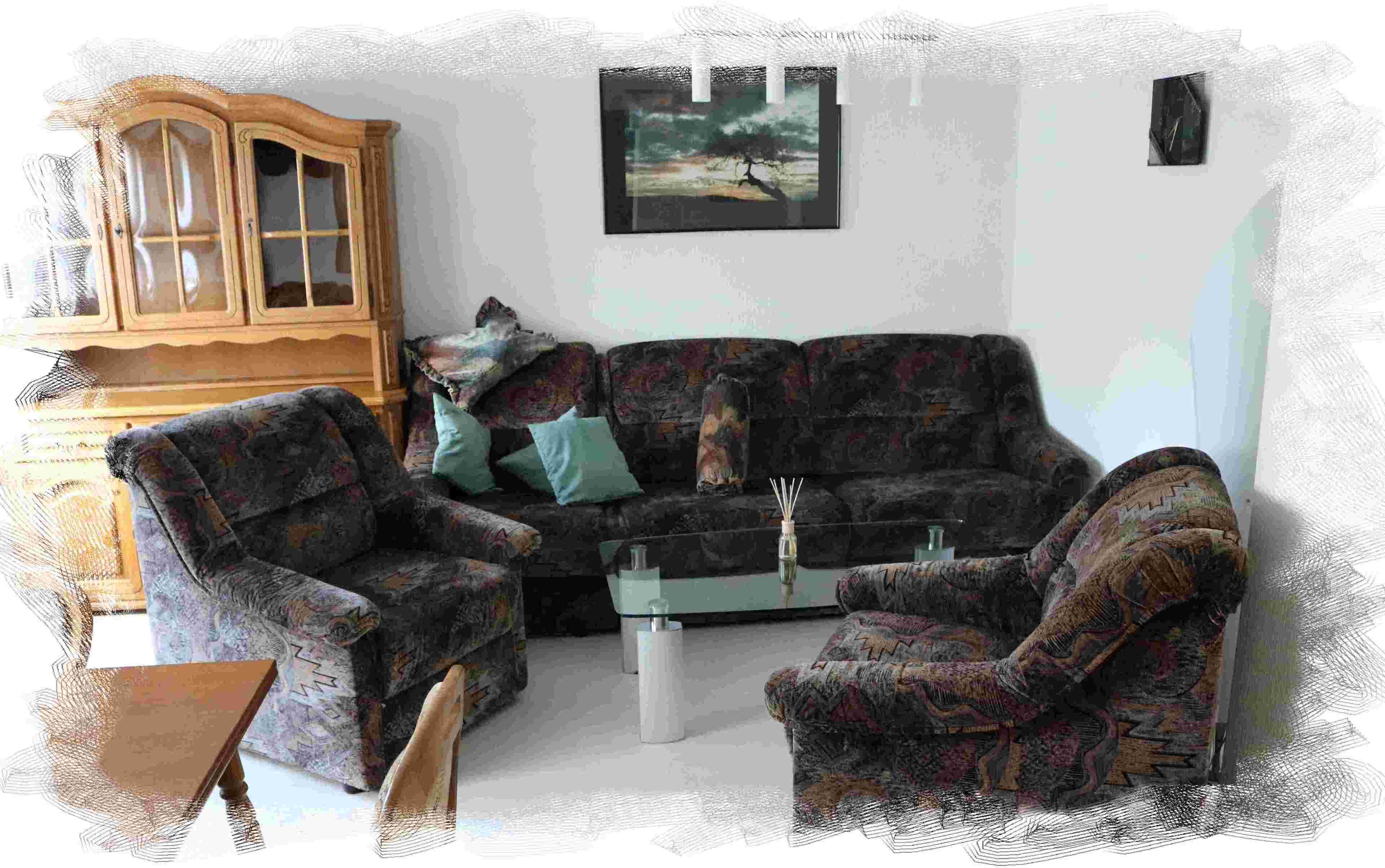 Een woonkamer met een donkere gestreepte bank, twee fauteuils, een houten kast en een glazen salontafel.