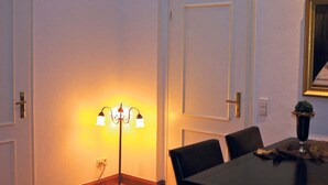 A dining area with a table, chairs, a floor lamp, and a door. - Apartment in Potsdam - Berlin suburb - near Holy Lake -<br><br> (Potsdam)