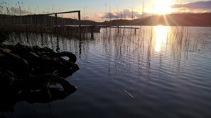 A calm lake with reeds and a wooden dock. - Holidays at Godendorfer See 300m, rowing boat, dog on request, fireplace, 2x toilet, 2 bedrooms (Godendorf)