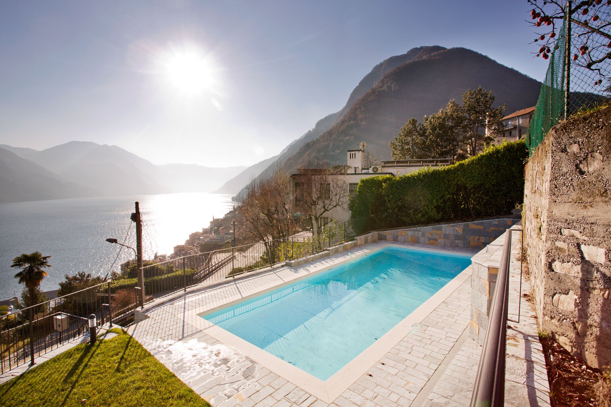 A swimming pool with a view of a lake and mountains.