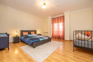 A bedroom with a bed, bedside tables, a nightstand, a chair, and a window with curtains. - Modern, large and beautiful villa with pool/garden in Azeitão south of Lisbon. (Azeitão, Setubal)