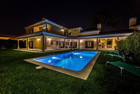 A two-story house with a swimming pool and outdoor seating. - Modern, large and beautiful villa with pool/garden in Azeitão south of Lisbon. (Azeitão, Setubal)