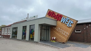 Un edificio con un cartello che riporta la scritta 'ANDERS WELT INDOOR SPIELPARK'.