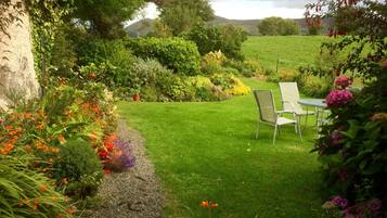 Stroll through the beautifully maintained garden, surrounded by a variety of flowering plants and a tranquil seating area.