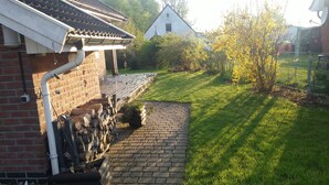 Una casa de maó amb teulada de rajola, un camí pavimentat i un jardí amb gespa.