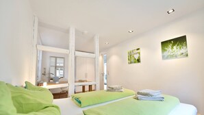 A bedroom with two beds, a desk, and a chair. There are two paintings on the wall. - Old Town Apartment "Himmelreich" (Heidelberg)
