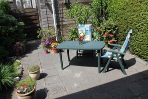 Relax on the patio surrounded by lush greenery and vibrant flowers.