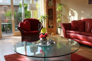 Relax in this stylish living room with a glass coffee table, comfortable seating, and a grandfather clock.