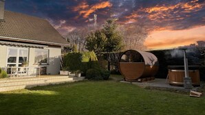 Una casa con jardín, sauna y bañera de hidromasaje.