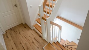 Un escalier en bois avec des rampes blanches menant à un palier.