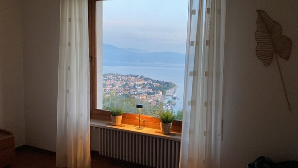 A room with a view of a lake and a town. - Romantic villa with a fantastic view of Lake Garda (Toscolano Maderno)