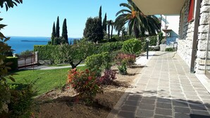 A stone pathway leading to a building with a view of the sea. - Romantic villa with a fantastic view of Lake Garda (Toscolano Maderno)