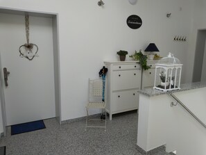 Welcome to a cozy space with a white door, a small cabinet, and a birdcage on the countertop.