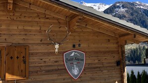 A wooden cabin with a sign reading "Chalet Kaprun" and a deer skull mounted on the wall.