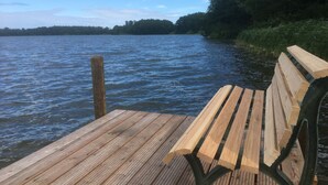 A wooden dock with a bench extending over a body of water. - Idyllic farm cottage only 600 m from the Baltic Sea, natural beach, no car traffic (Barkelsby-Hemmelmark)