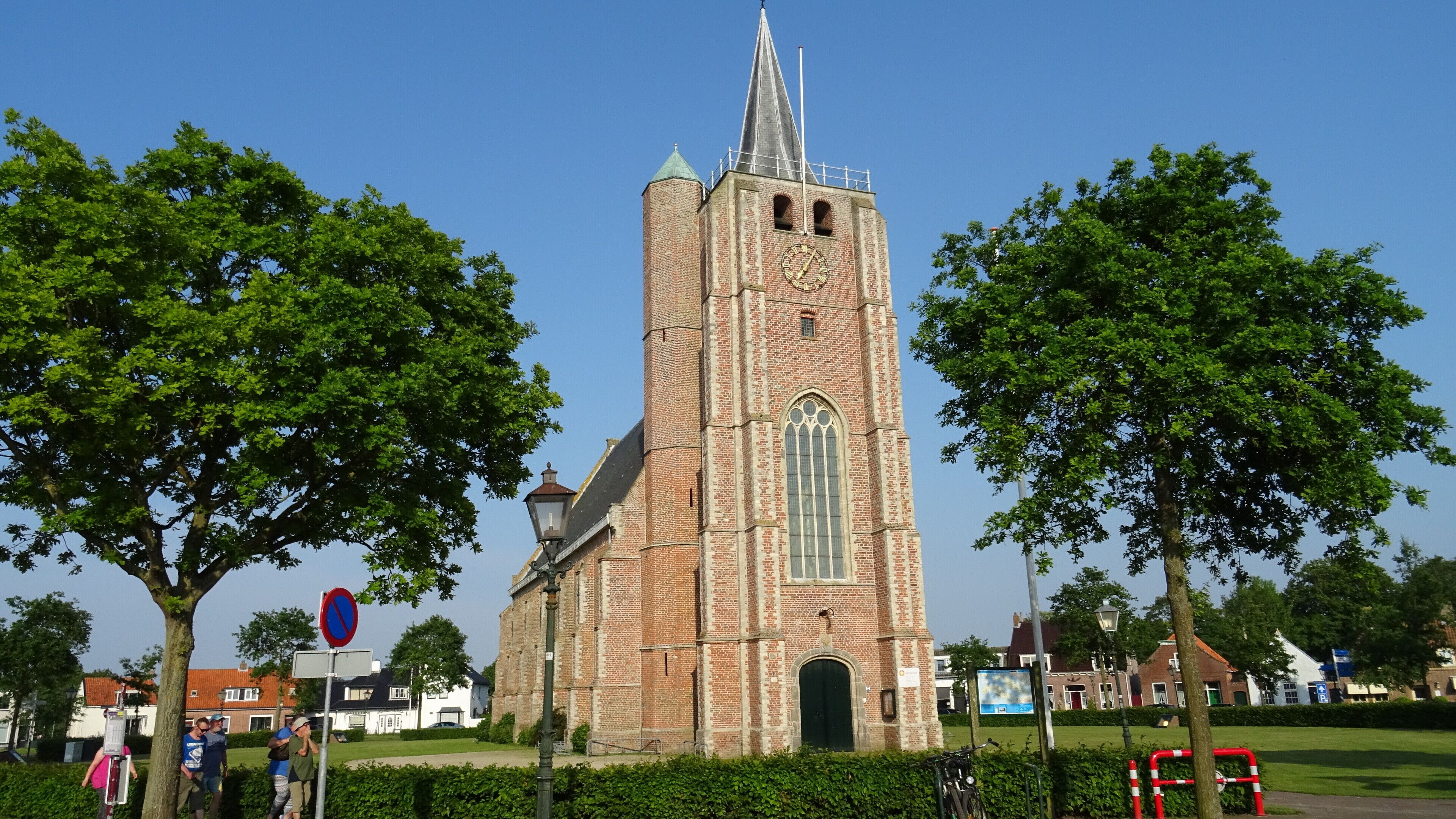 En historisk kyrka med ett högt torn och ett stort, välvt fönster.