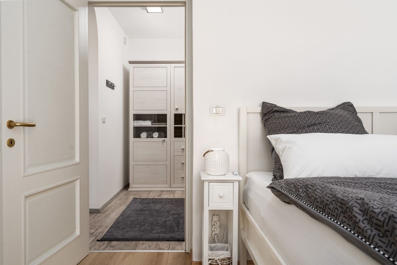 Ein Schlafzimmer mit Bett, Nachttisch und Kleiderschrank.
